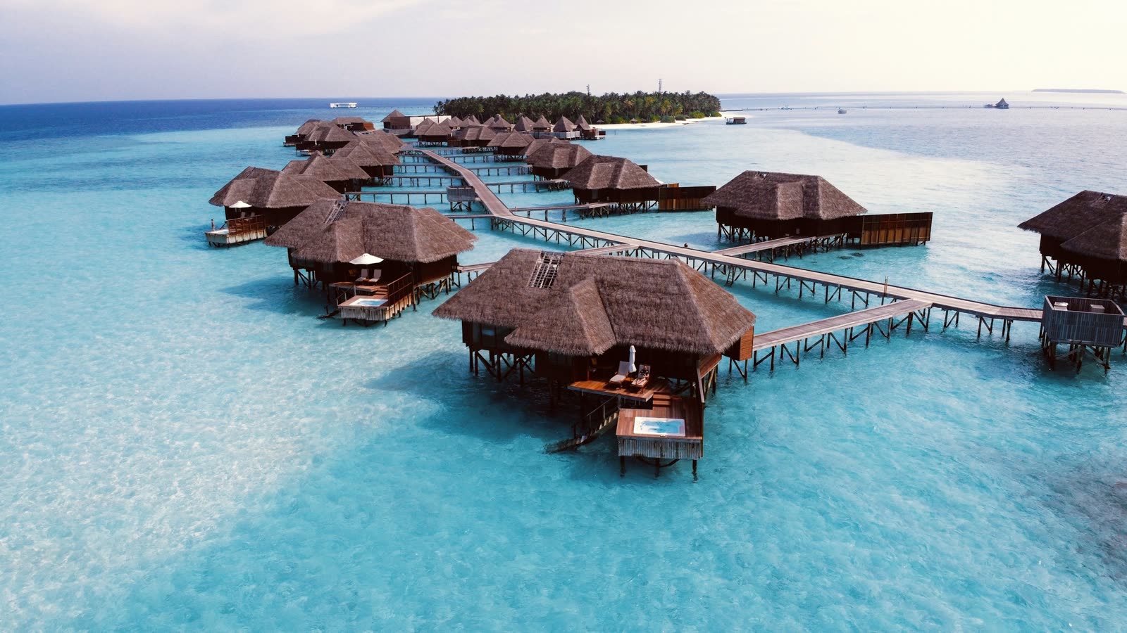 An overwater villa deck above clear blue Maldives water